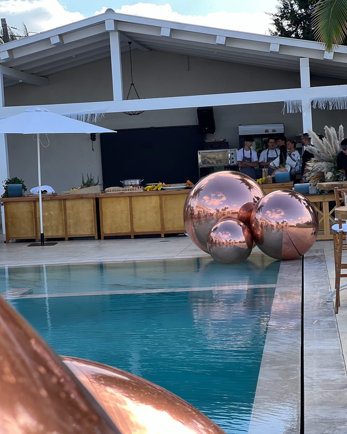 Ballons miroirs aux reflets cuivrés autour d’une piscine