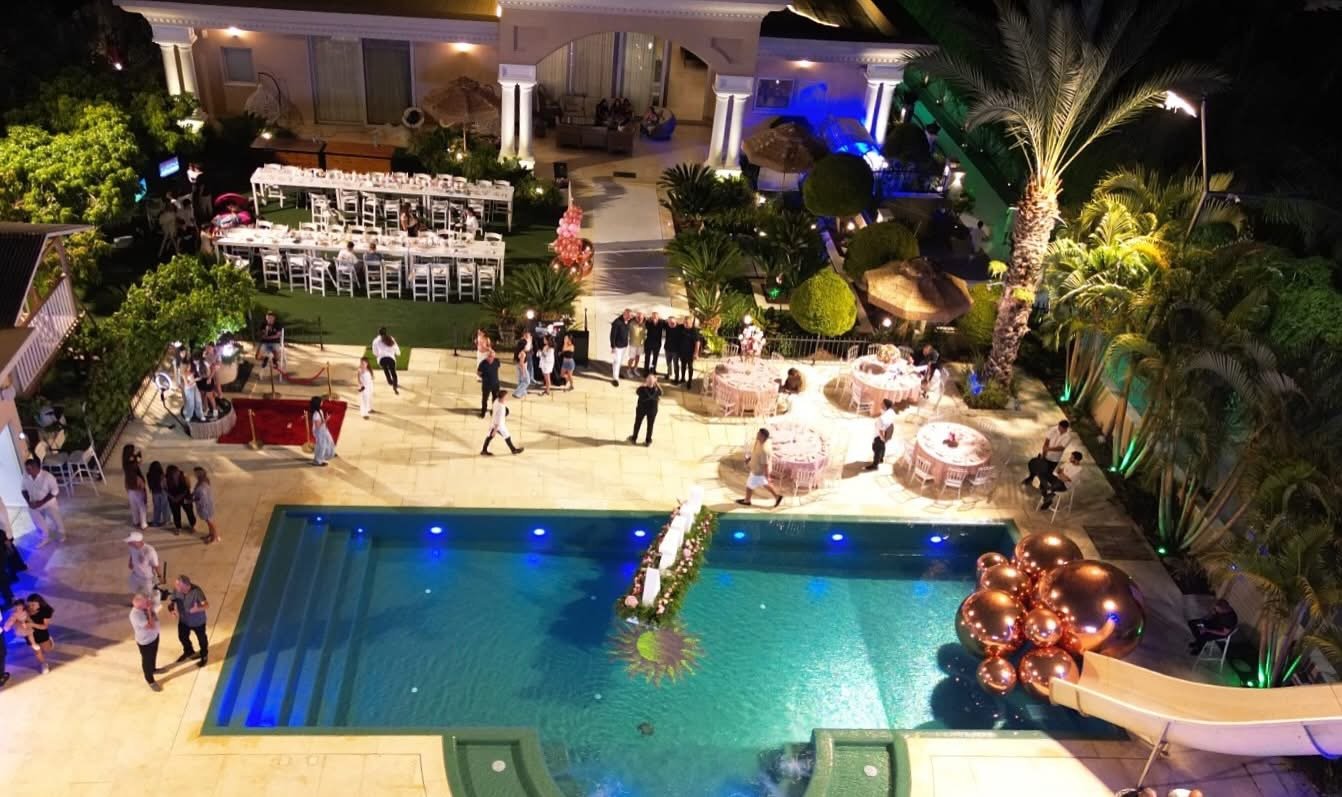 Vue nocturne d’une réception autour d’une piscine décorée de ballons miroirs