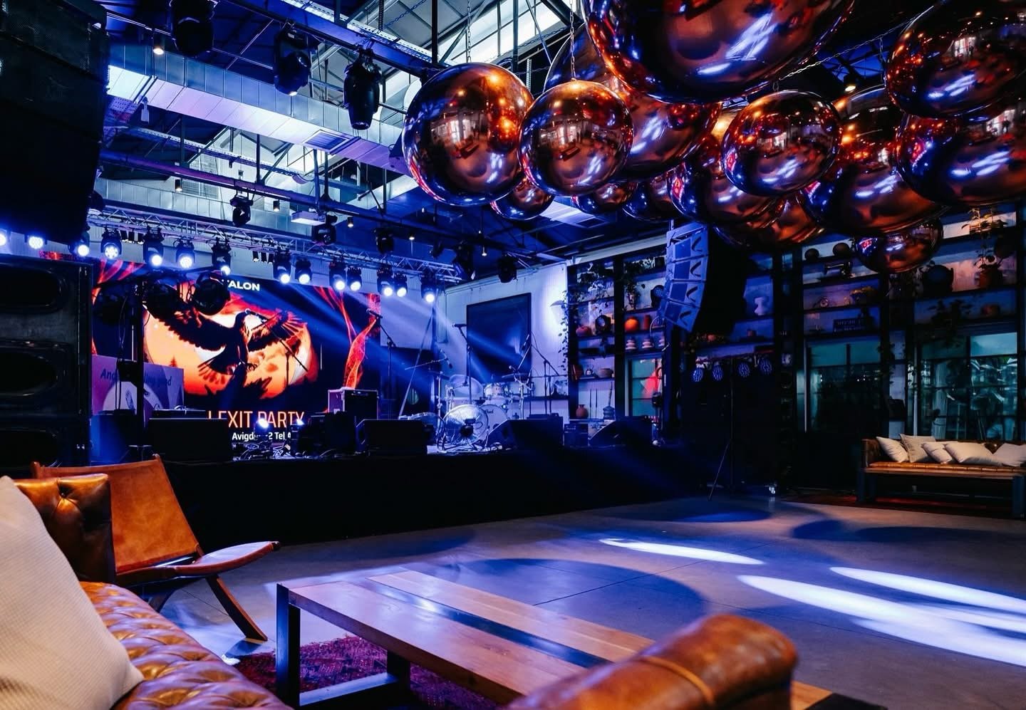 Ballons miroirs suspendus dans une salle de concert aux lumières colorées