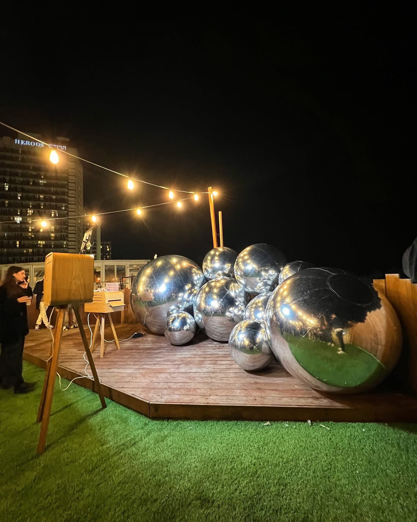 Ballons miroirs argentés sur une terrasse illuminée de nuit