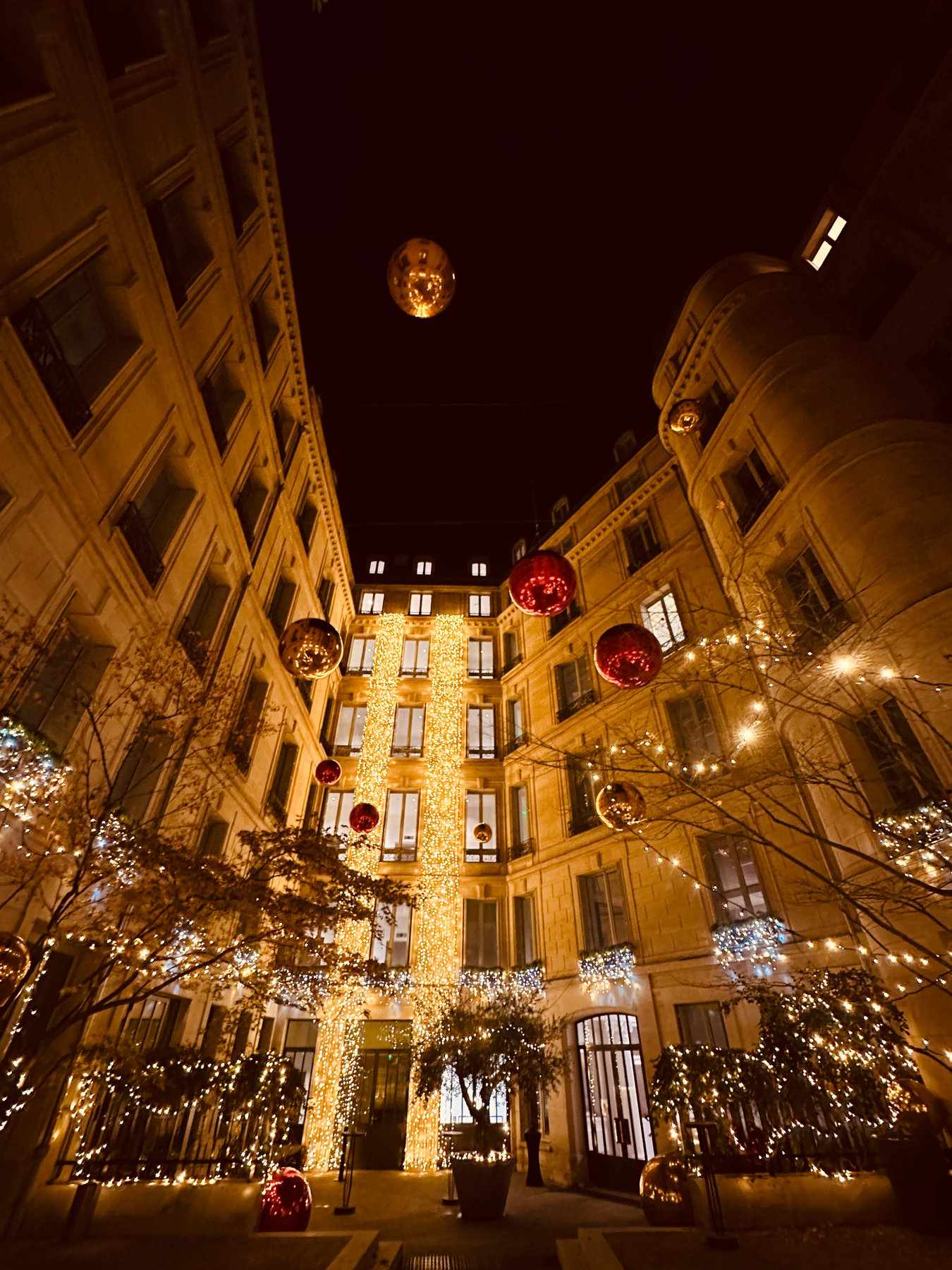 Décor nocturne avec ballons miroirs suspendus entre des façades