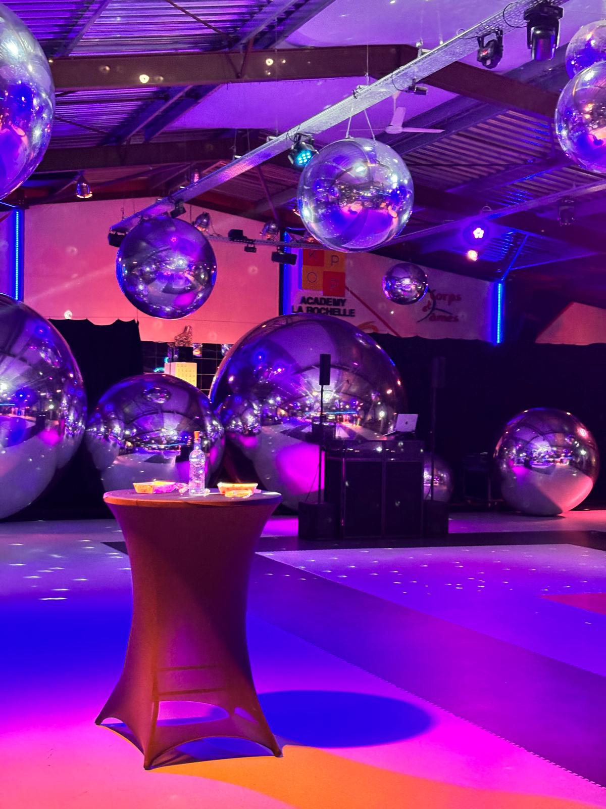 Composition de ballons miroirs argentés avec des mange-debout en soirée