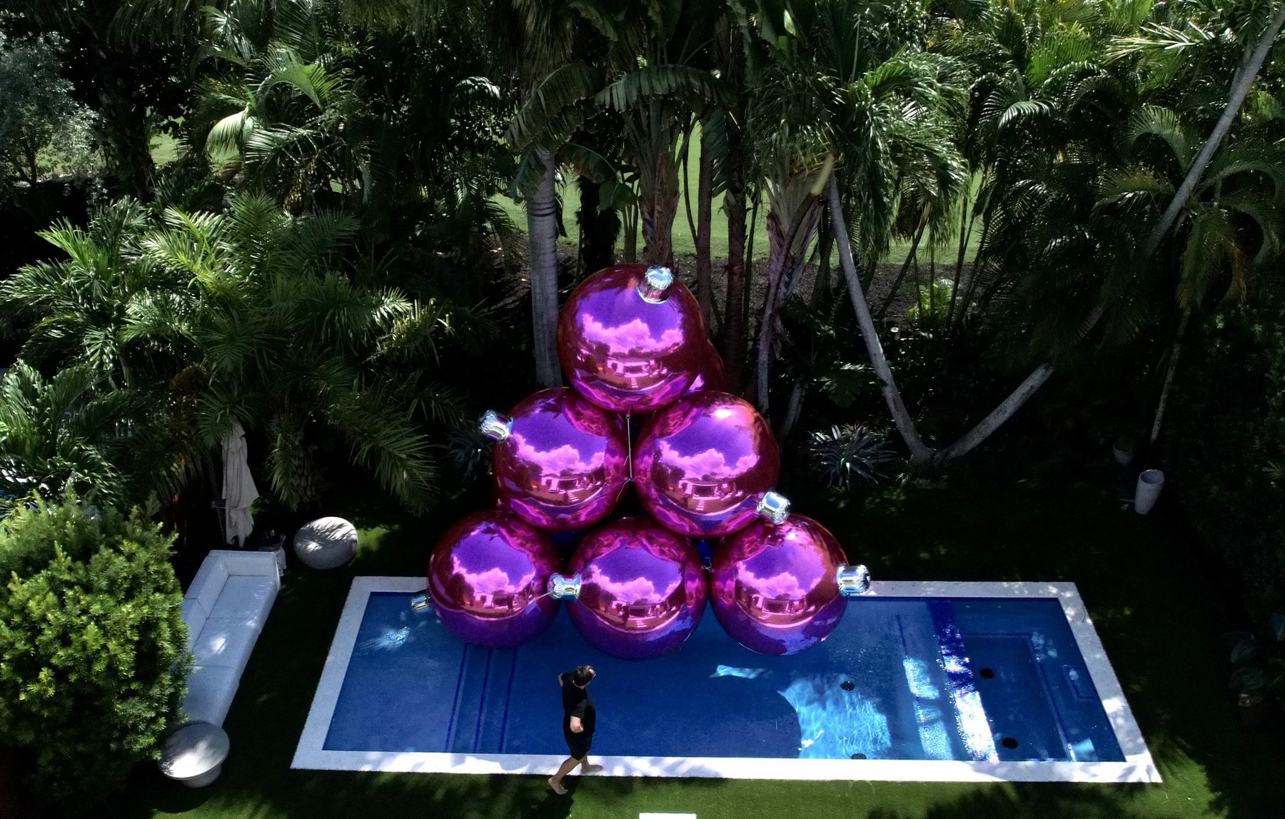 Composition de ballons miroirs roses près d’une piscine dans un jardin