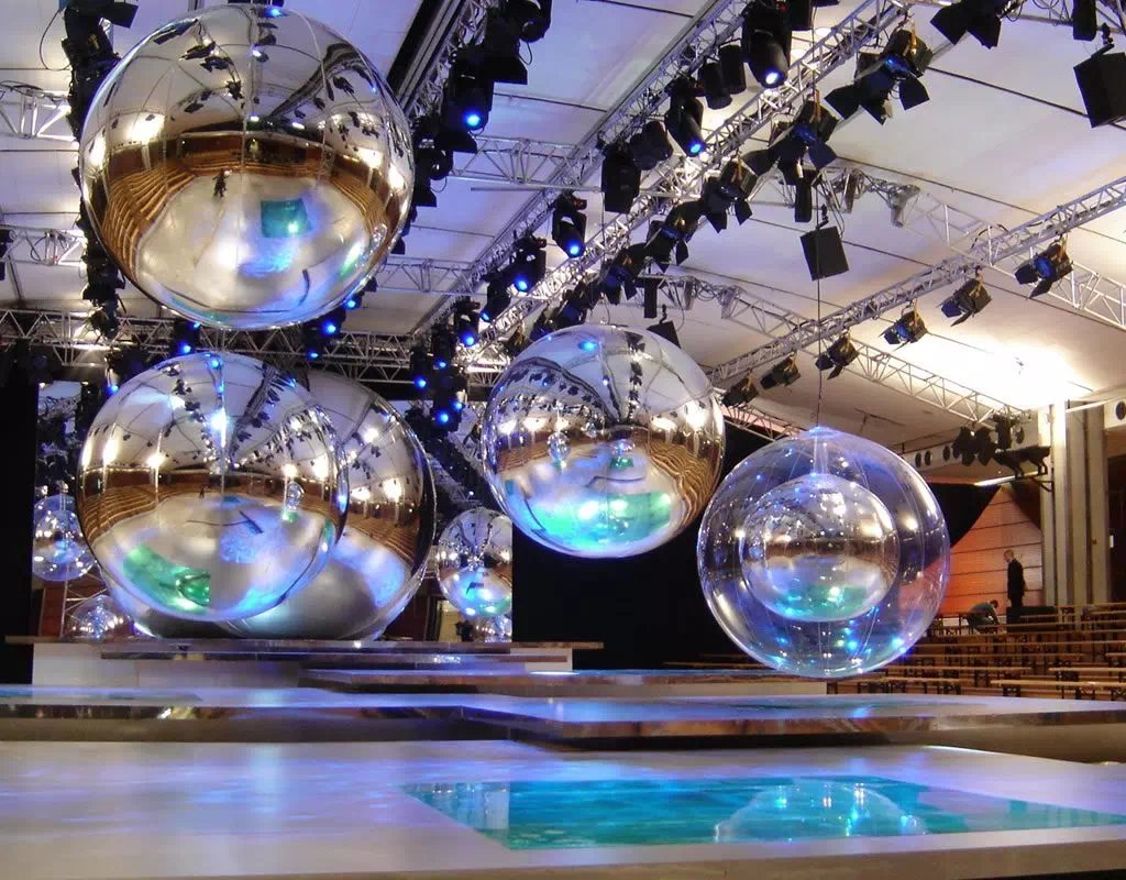 Ballons miroirs argentés suspendus dans une salle événementielle