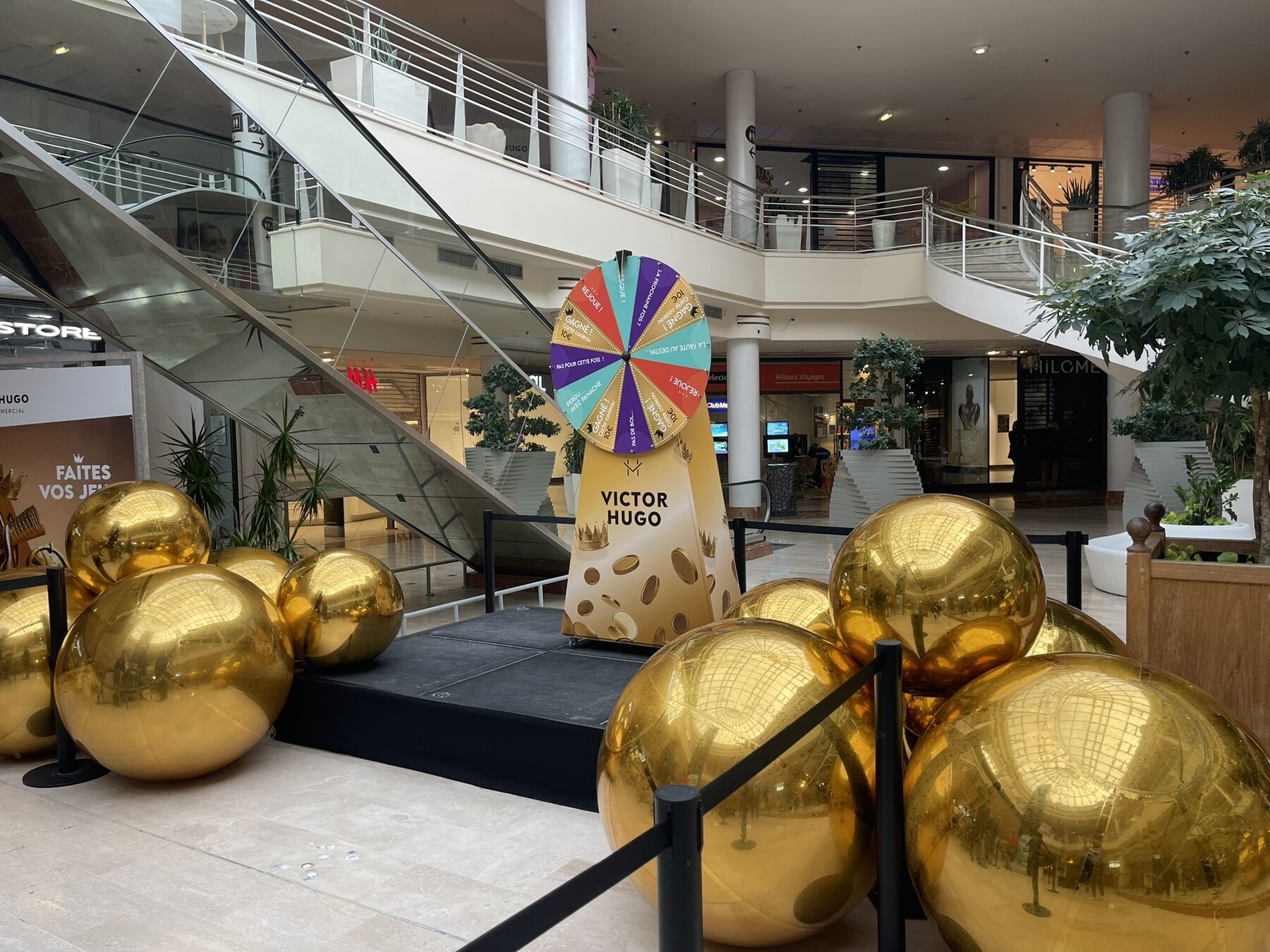 Ballons miroirs dorés posés dans un centre commercial